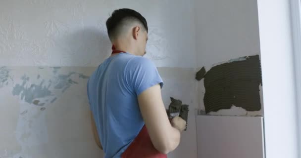 男主人把瓷砖粘在墙上 把白砖放在厨房里 — 图库视频影像