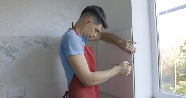 Αρσενικό Τεχνίτης Εγκατάσταση Κεραμικών Πλακιδίων Στον Τοίχο Ξαπλώνοντας Λευκά Πλακάκια — Αρχείο Βίντεο