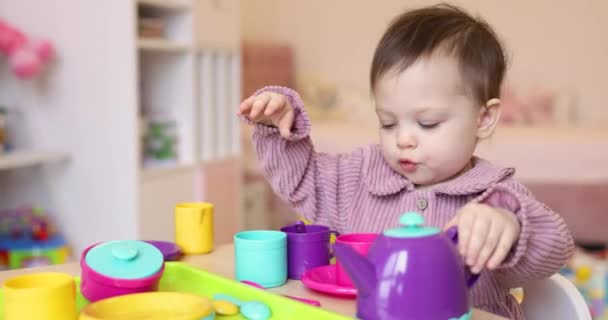 彼女の部屋でプラスチックおもちゃティーカップで遊んでいる幸せなかわいい小さな子供の赤ん坊の女の子 — ストック動画