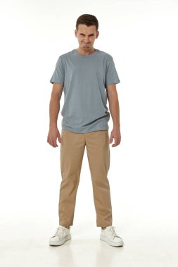 Beyaz stüdyo arka planında duran sinirli adam.