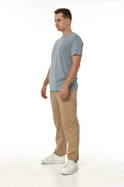 Beyaz stüdyo arka planında duran sinirli adam.