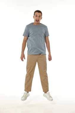 Beyaz stüdyo arka planında kameraya bakan şaşırmış bir adam.