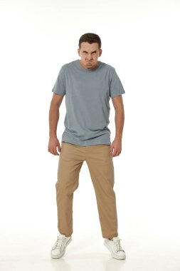 Beyaz stüdyo arka planında bağıran sinirli adam.