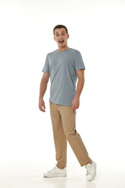 Beyaz stüdyo arka planında kameraya bakan şaşırmış bir adam.