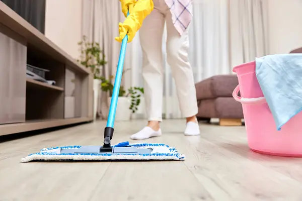 young woman cleaning floor with wet mop at home , daily housekeeping , close-up