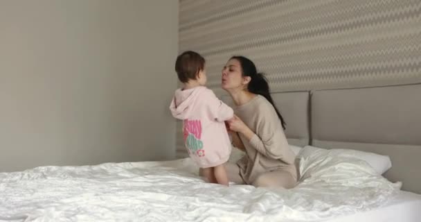 Молода Мати Лоскоче Свою Маленьку Доньку Ранковій Спальні — стокове відео