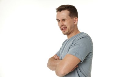 Genç mutlu bir adamın beyaz arka plandaki kameraya göz kırpan portresi.