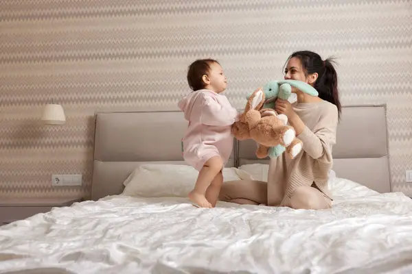 Счастливая Мать Маленькая Дочь Играют Игрушками Зайчиками Спальне Веселая Семья — стоковое фото