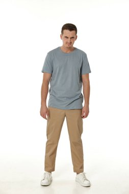 Beyaz stüdyo arka planında duran sinirli adam.