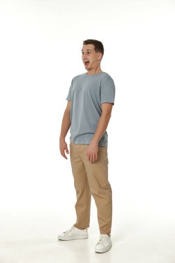 Beyaz stüdyo arka planında kameraya bakan şaşırmış bir adam.