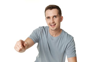 Mutlu adam beyaz stüdyo arka planında kamerayı işaret ediyor.