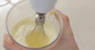 Tatlı pişirmek için elektrikli mikser kullanan kadın elleri..