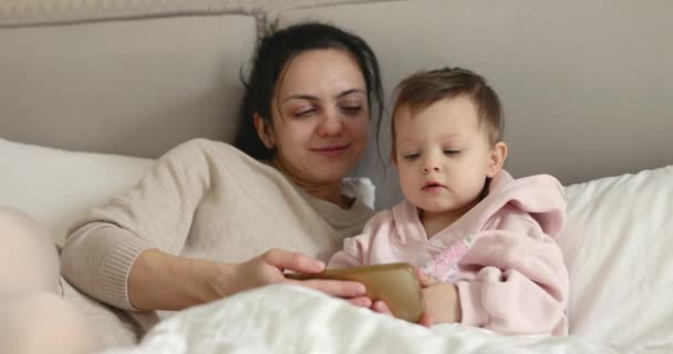Μητέρα Και Παιδί Παίζουν Smartphone Ενώ Κάθονται Στο Κρεβάτι Στο — Αρχείο Βίντεο