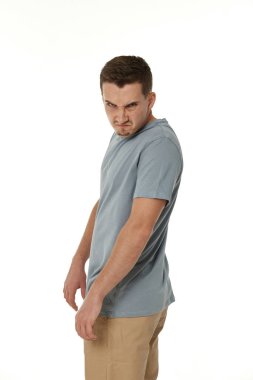 Beyaz stüdyo arka planında duran sinirli adam.