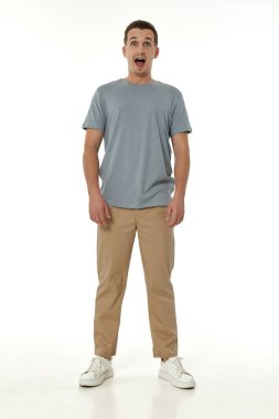 Beyaz stüdyo arka planında kameraya bakan şaşırmış bir adam.