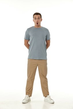 Beyaz stüdyo arka planında kameraya bakan şaşırmış bir adam.