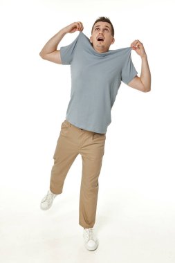 Beyaz arka planda kendini omuzlarından tutan bir adam.