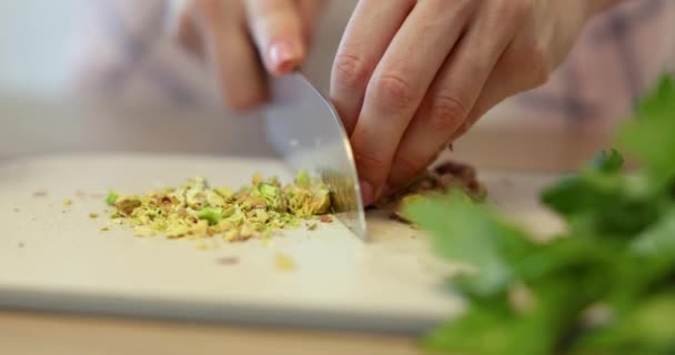 大きなキッチンナイフで切断板にピスタチオを切断する女性の手 — ストック動画