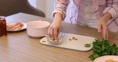 Kadın elleri mutfakta salata hazırlamak için fıstık kabuğu kırıyor.