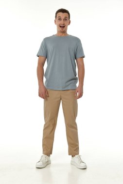 Beyaz stüdyo arka planında kameraya bakan şaşırmış bir adam.