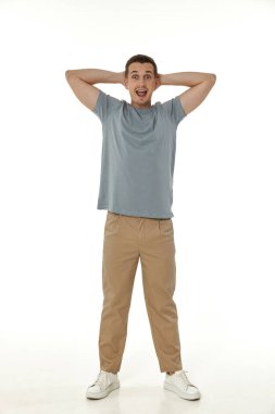 Beyaz stüdyo arka planında kameraya bakan şaşırmış bir adam.