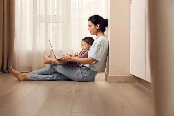 Bela Mulher Casual Sentado Chão Trabalhando Laptop Com Sua Menina Imagem De Stock