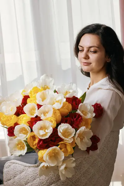 Schöne Frau Mit Frühlingsblumen Tulpen Den Händen Sitzt Auf Stuhl Stockfoto