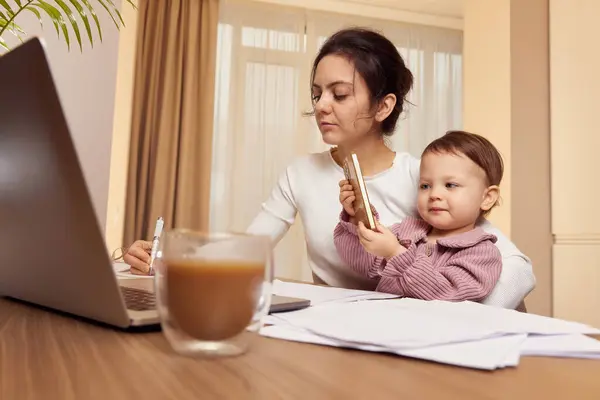 Fröhliche Hübsche Geschäftsfrau Die Hause Mit Ihrem Kleinen Kind Laptop lizenzfreie Stockfotos