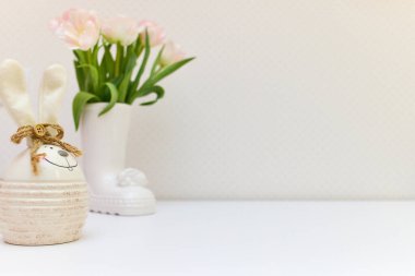 Beyaz masada bir buket lale ve Paskalya tavşanı. Boşluğu kopyala