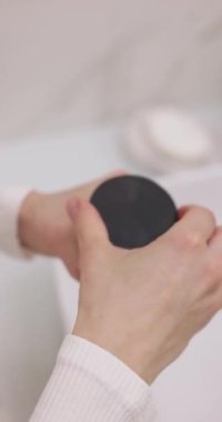 Yakın plan, kadın elleri kilden bir maskeyle kavanozu açıyor.