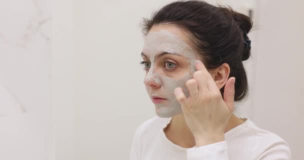 Blanke Vrouw Zoek Spiegel Het Aanbrengen Van Gezichtsmasker Witte Badkamer — Stockvideo