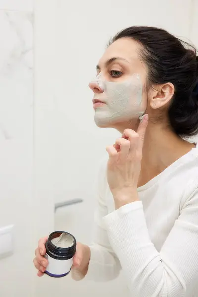Caucasian Woman Looking Mirror Applying Face Mask White Bathroom Royalty Free Stock Images