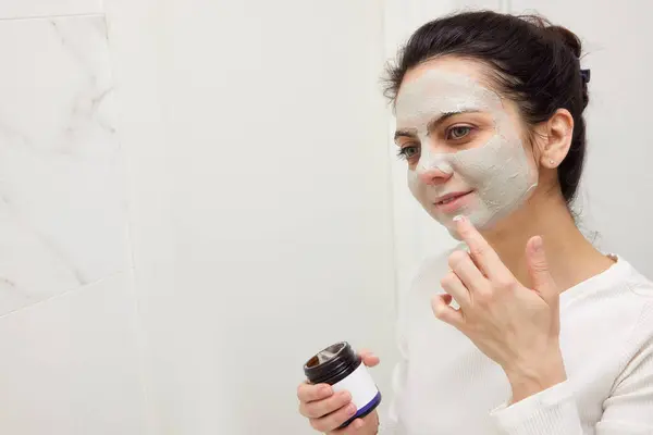Caucasian Woman Looking Mirror Applying Face Mask White Bathroom Copy Stock Photo