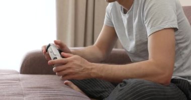Erkek eller evde video oyunu oynuyor, yakın çekim, oyuncu konsolda joystick kullanıyor