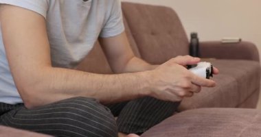 Erkek eller evde video oyunu oynuyor, yakın çekim, oyuncu konsolda joystick kullanıyor