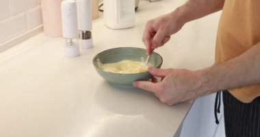 Kafkas adam yumurta çırpıyor ve kahvaltıya omlet hazırlıyor.