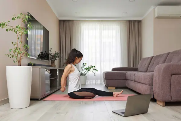 Stock image sporty woman stretching hands and warm up arm for exercise at home, online training