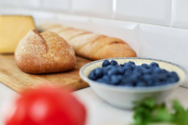 Beyaz masadaki cam kasede ev yapımı çavdar ekmeği ve yabanmersini. Sağlıklı beslenme