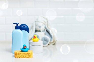 Sarı lastik ördek, sabun, banyo zemininde banyo köpüğü, çocuk banyo aksesuarları. Boşluğu kopyala