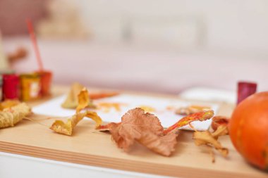 Sonbahar yaprakları kağıt üzerinde boya fırçası ile masada, sonbahar çocukları arka planda