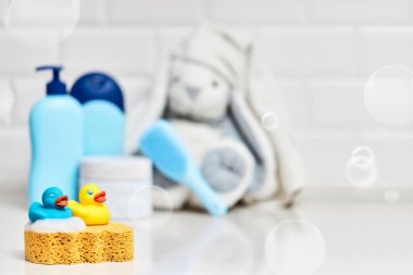 Sarı lastik ördek, sabun, banyo zemininde banyo köpüğü, çocuk banyo aksesuarları.