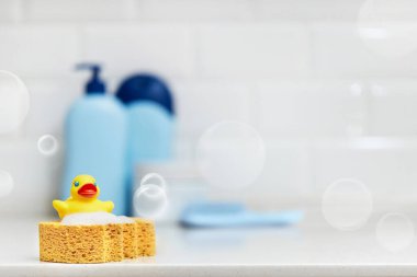 Sarı lastik ördek, sabun, banyo zemininde banyo köpüğü, bebek banyosu aksesuarları. Boşluğu kopyala