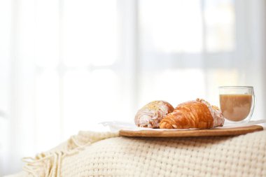 Delicious fresh french croissants and glass of coffee on wooden tray for breakfast in bed in the morning, tasty breakfast, copy space clipart