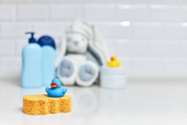 Sarı lastik ördek, sabun, banyo zemininde banyo köpüğü, bebek banyosu aksesuarları.