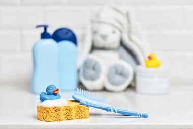 Sarı lastik ördek, sabun, banyo zemininde banyo köpüğü, çocuk banyo aksesuarları.