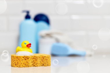 Sarı lastik ördek, sabun, banyo zemininde banyo köpüğü, çocuk banyo aksesuarları.