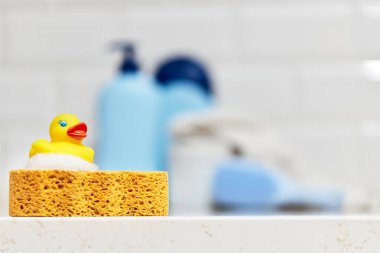 Sarı lastik ördek, sabun, banyo zemininde banyo köpüğü, bebek banyosu aksesuarları.