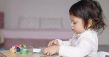 Kağıt çelenk yapıştırıp Noel 'e hazırlanan sevimli küçük bir kız çocuğu. Noel konsepti, çocuk gelişimi