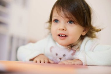 Evdeki masada oturan küçük kız çocuğu, çocuk gelişimi..