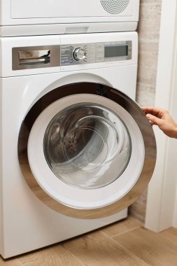 Kadın eli evde çamaşır makinesinin kapısını açar ya da kapatır